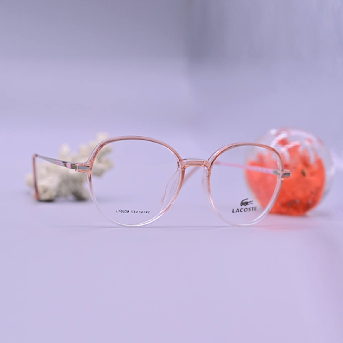 نظارة طبية من ماركة لاجوست موديل 6609، إطار دائري كامل بلون وردي شفاف (Crystal Pink) مع أذرع معدنية نحيفة باللون الذهبي الوردي، متوفرة لدى عين العون.