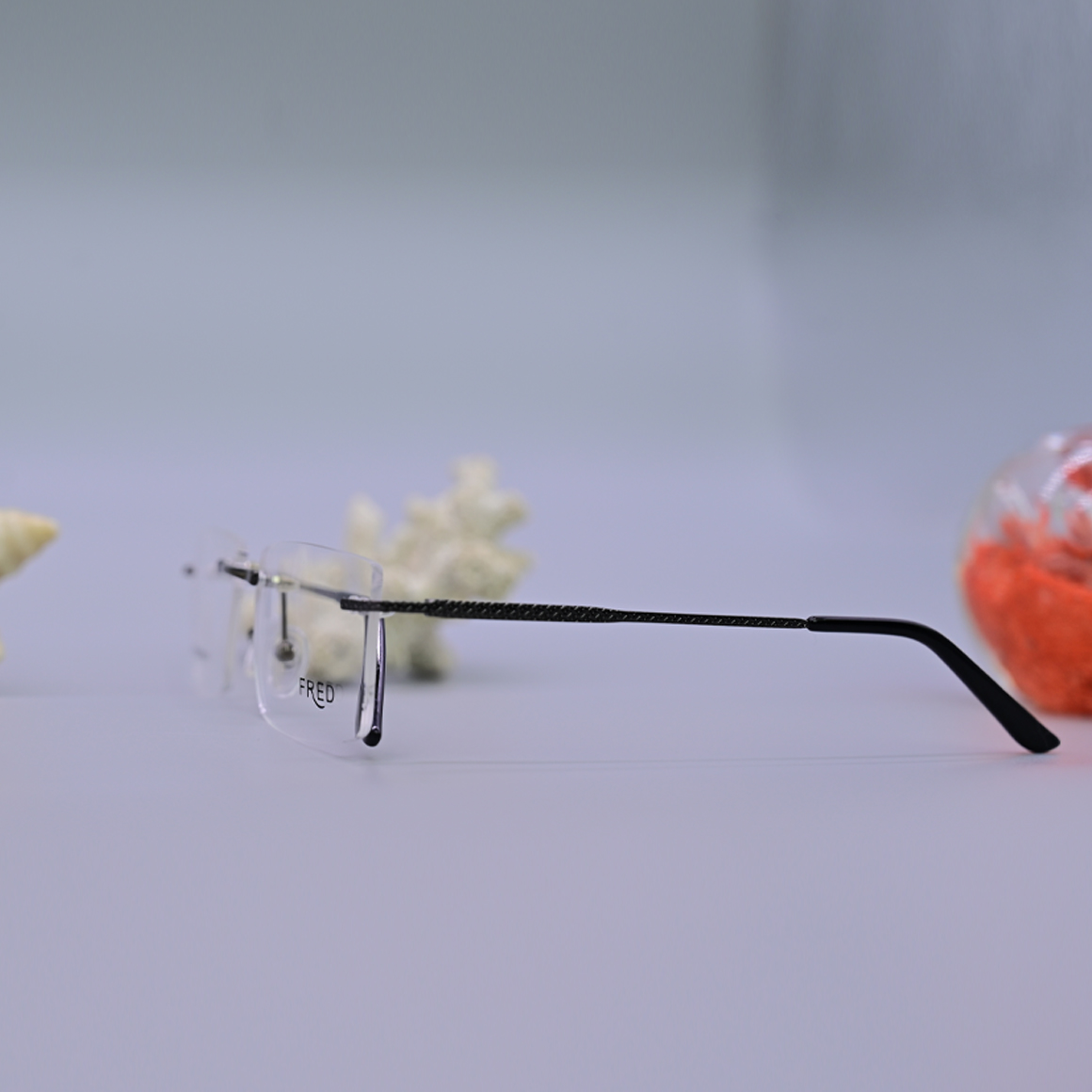 نظارة طبية ماركة فريد (Fred) موديل 3601 بدون إطار، تتميز بعدسات مائلة للاستدارة وأذرع معدنية رفيعة تمنح مظهراً كلاسيكياً هادئاً، متوفرة لدى متجر عين العون.