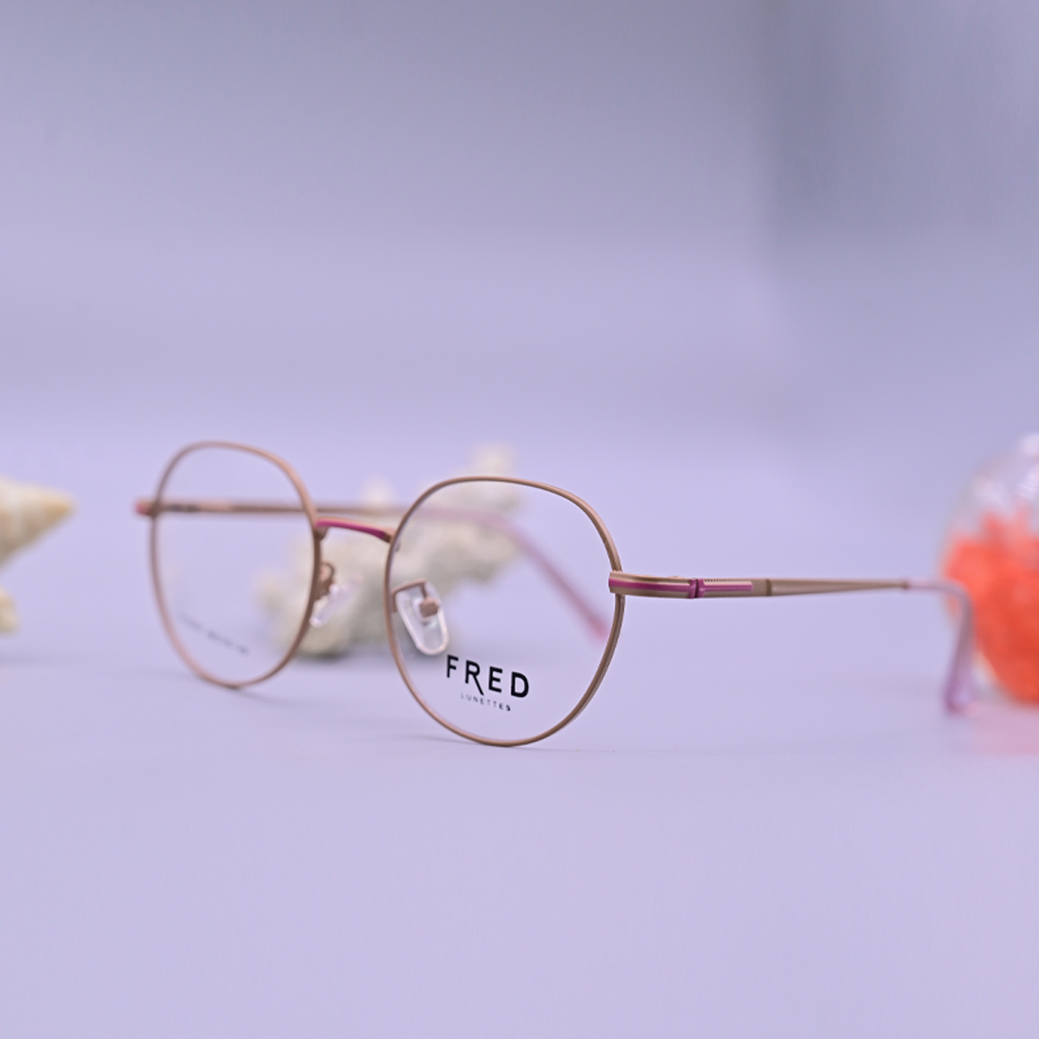 نظارة طبية ماركة فريد موديل 8891 بإطار كامل وردي نحيف وتصميم دائري هندسي مع جسر أنف ذهبي وأذرع رقيقة.