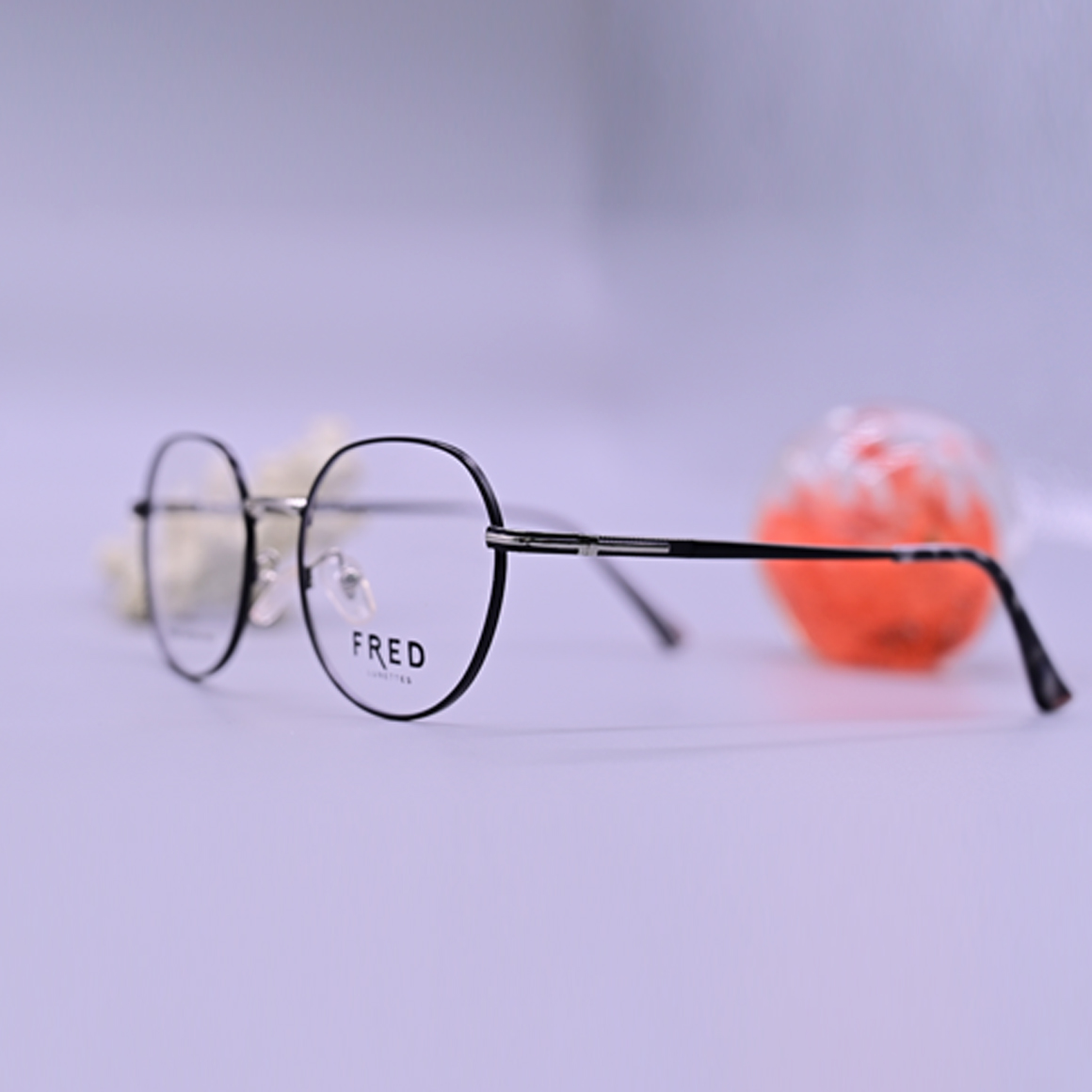 نظارة طبية ماركة فريد موديل 8891 بإطار كامل أسود وتصميم دائري عصري مع جسر أنف معدني رفيع وأذرع نحيفة تحمل شعار الماركة.