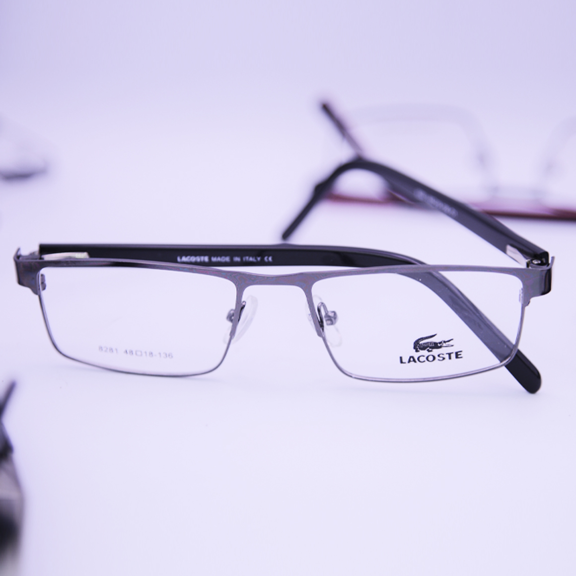 نظارة لاجوست (Lacoste) طبية موديل 8281 بنمط نصف حافة وتصميم مستطيل بلون داكن فخم مع أذرع انسيابية تحمل شعار الماركة من متجر عين العون.