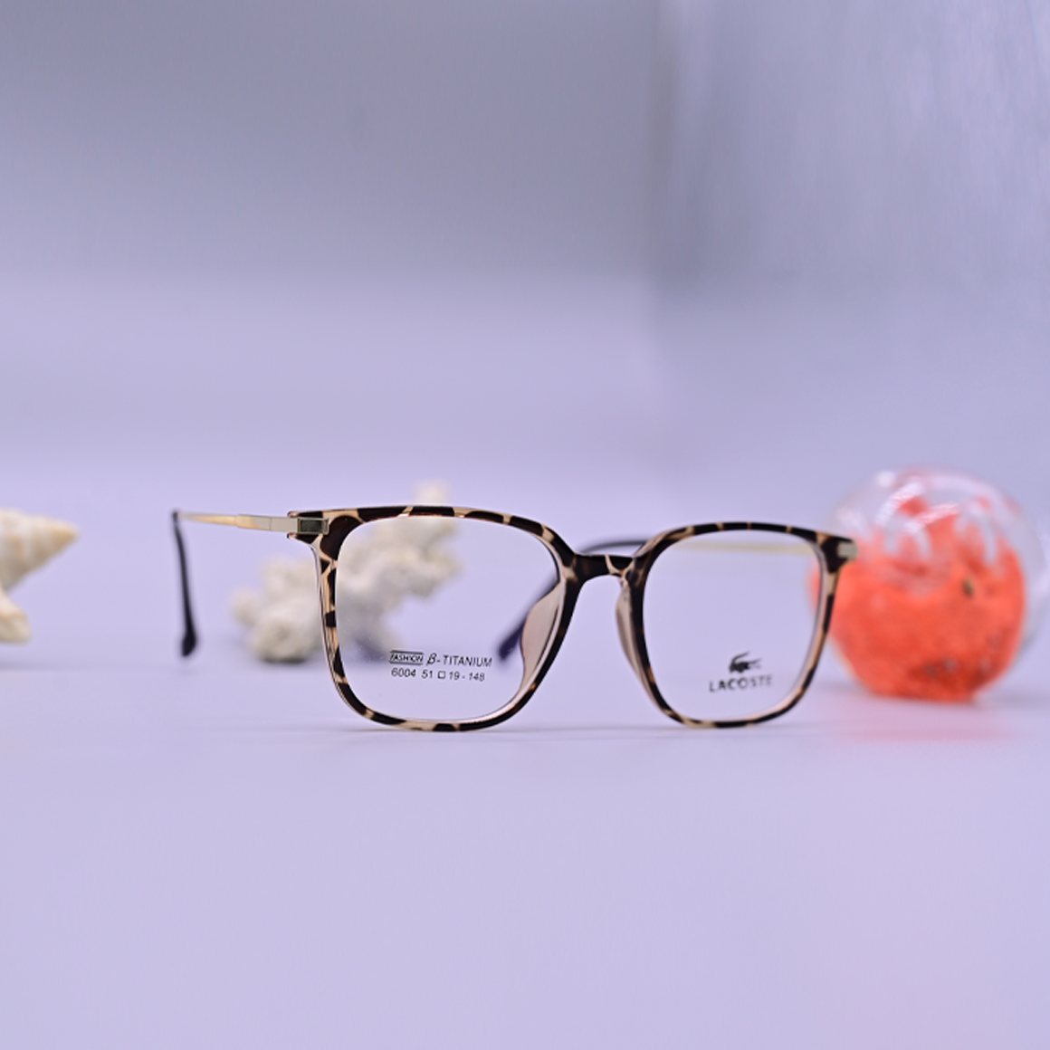 نظارة لاكوست (Lacoste) طبية موديل 6004 بإطار كامل وشكل دائري، تتميز بنقشة الرخامي البني (التايجر) التي تضفي لمسة كلاسيكية راقية، متوفرة لدى متجر عين العون.