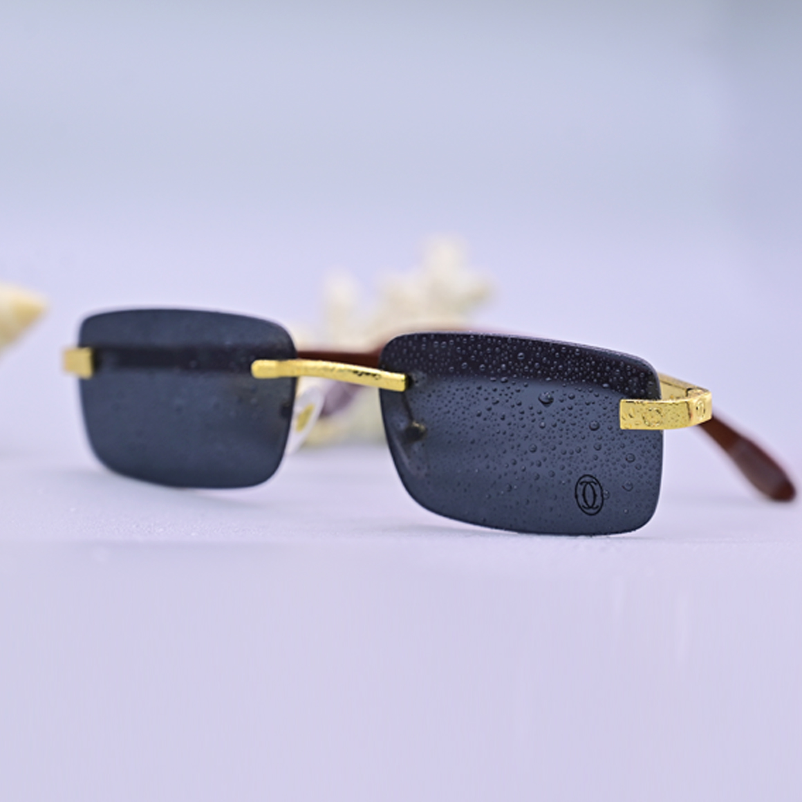 نظارة طبية فاخرة ماركة كارتير موديل 3021، تصميم بدون إطار (Rimless) بعدسات رمادية داكنة وأذرع خشبية بنية مع تفاصيل معدنية ذهبية، متوفرة لدى عين العون.