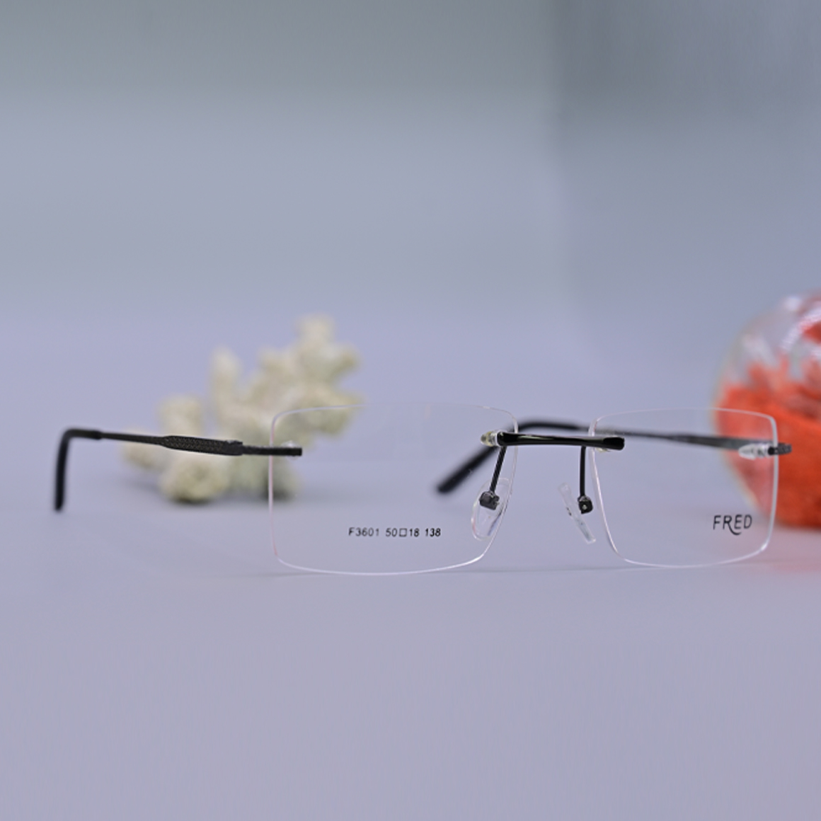 نظارة طبية ماركة فريد (Fred) موديل 3601 بدون إطار، تتميز بعدسات مائلة للاستدارة وأذرع معدنية رفيعة تمنح مظهراً كلاسيكياً هادئاً، متوفرة لدى متجر عين العون.