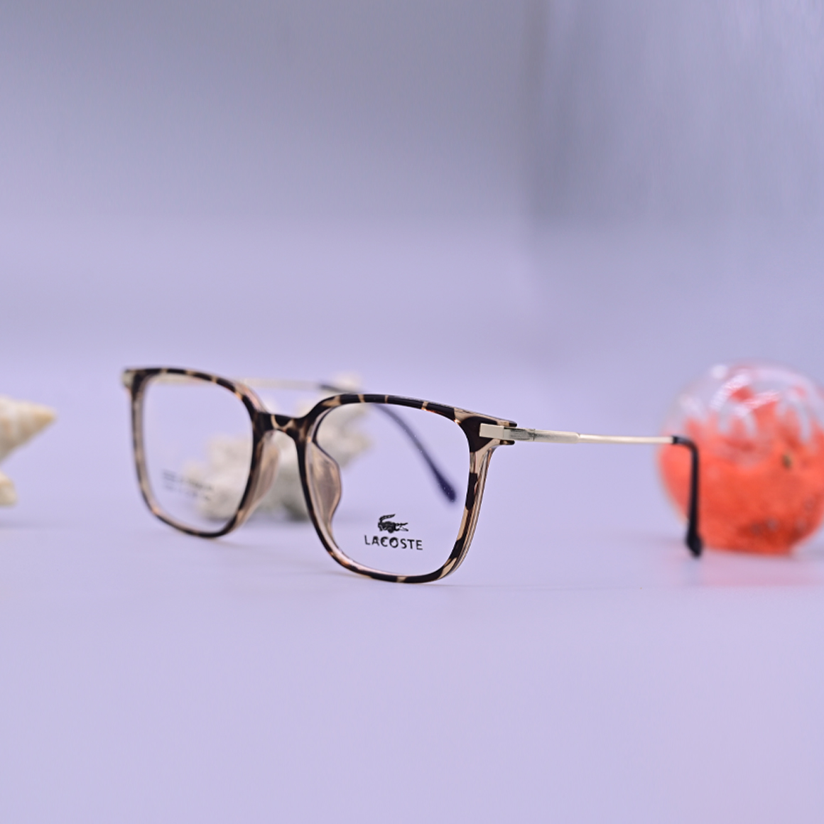 نظارة لاكوست (Lacoste) طبية موديل 6004 بإطار كامل وشكل دائري، تتميز بنقشة الرخامي البني (التايجر) التي تضفي لمسة كلاسيكية راقية، متوفرة لدى متجر عين العون.