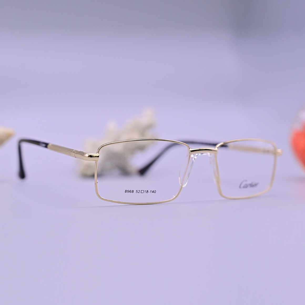 نظارة طبية ماركة كارتير موديل 8968 بإطار كامل مستطيل بلون ذهبي براق مع جسر أنف شفاف وأذرع ذهبية تنتهي بأطراف سوداء.